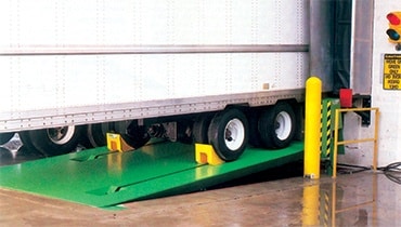 A truck at a loading dock with vehicle restraints